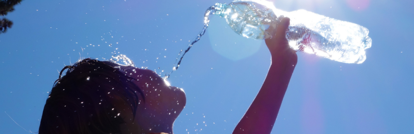 Child pouring water onto his face.