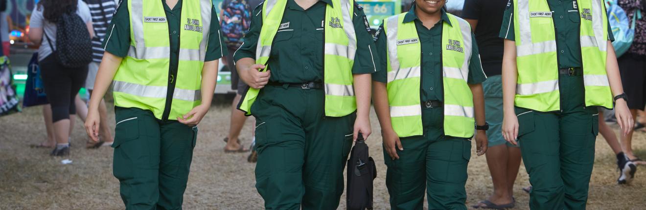 Four St John volunteers walking side by side.