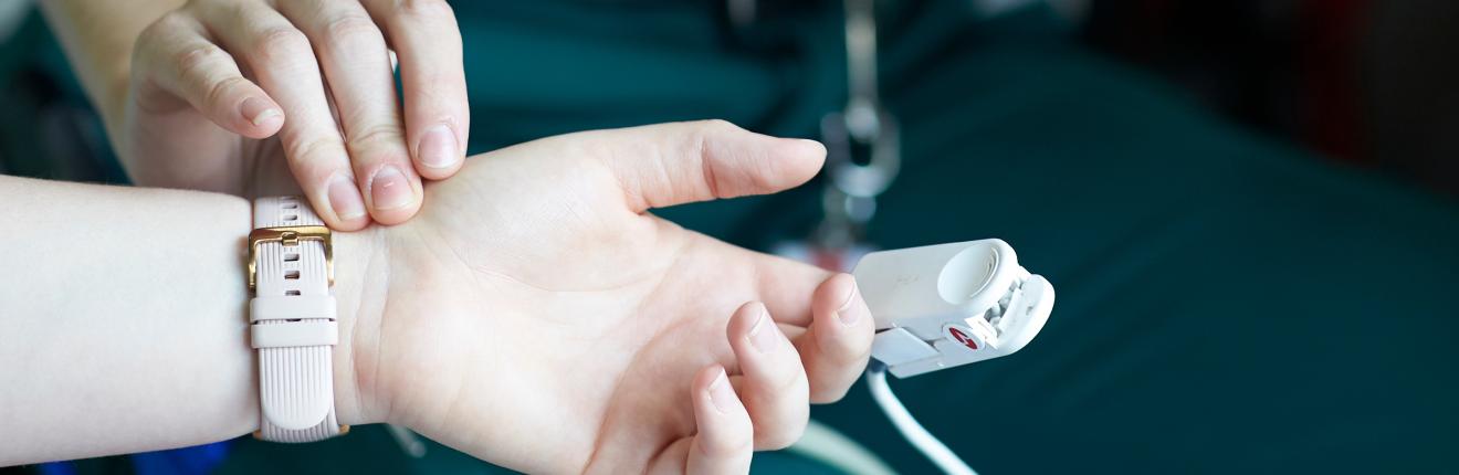 Paramedic measuring patient's heartrate.