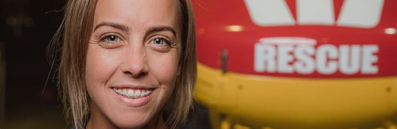 Caity in front of a rescue helicopter.